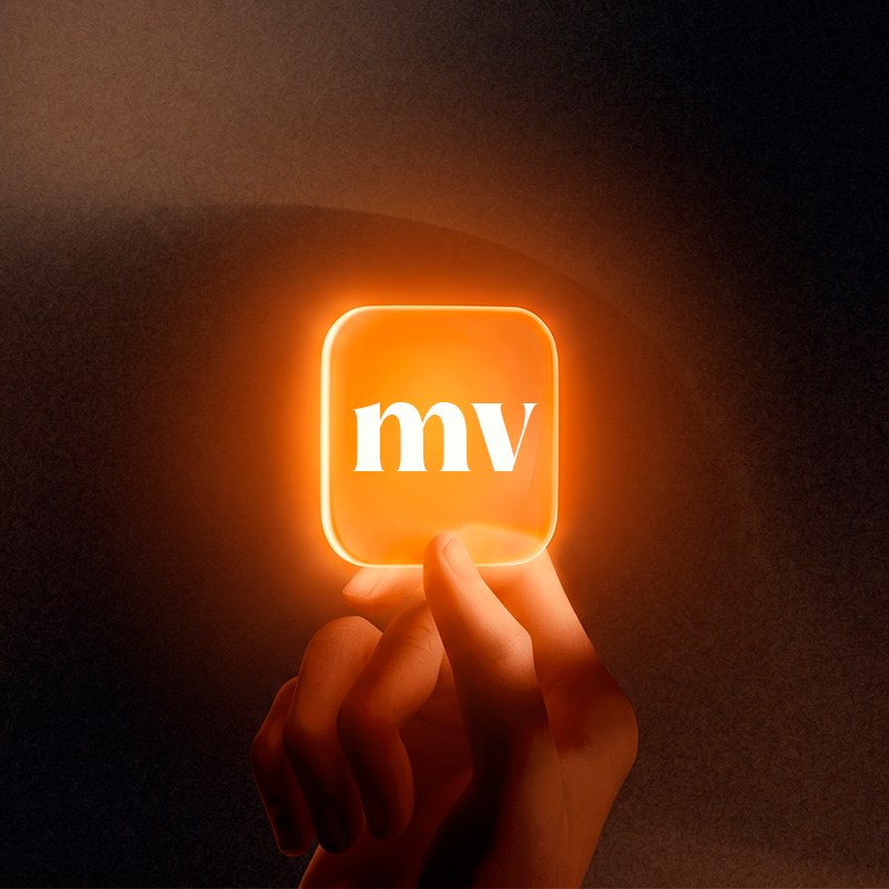 Mão segurando um ícone luminoso laranja com as letras mv, símbolo da Marca Viva